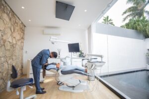 A dentist performs a dental exam in a modern practice environment.